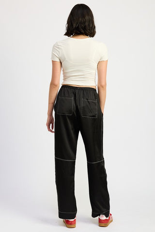 hem and leg close up black satin wide leg pants showing white contrast topstitching at hem and wide straight leg