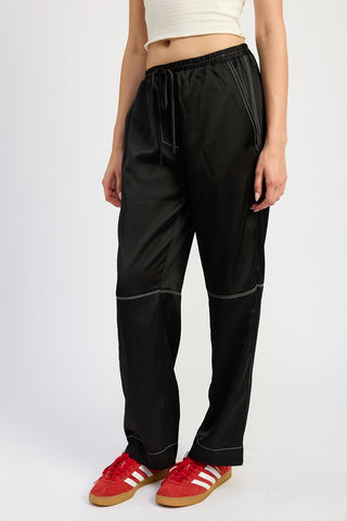 close up waist detail black satin wide leg pants showing white contrast topstitch at seams and drawstring waist