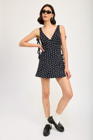 close up bodice black polka dot ruffle mini dress showing deep V-neck detail and top of cascade side ruffle panels