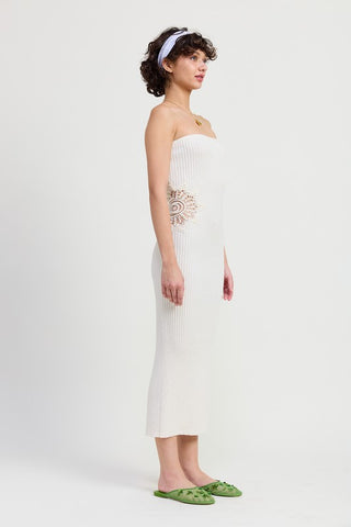 styled close up white strapless bodycon midi dress showing crochet doily hip patch detail and woven bag accessory