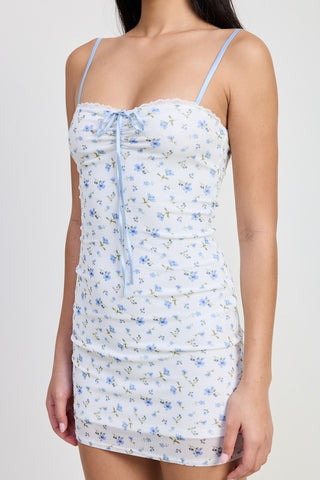 close up bodice detail blue ditsy floral ruched mini dress showing lace scallop neckline and center satin ribbon tie
