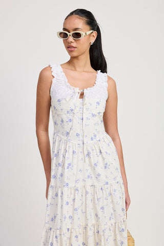 full length front view eyelet cotton midi dress blue rose print with broderie collar and center ribbon, white sandals
