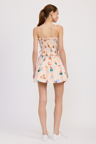 model in cotton poplin mini dress full view with white sneakers showing tiered skirt beach illustration print