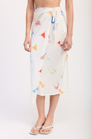 three quarter view white novelty flag print satin midi skirt showing side ruched drape silhouette and midi length