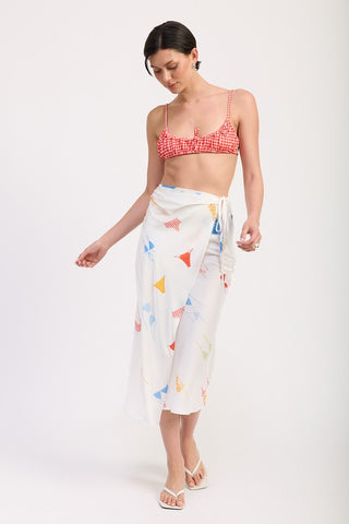 Gala printed satin midi skirt front view, multicolor bunting flag novelty print, side ruche sash tie, red gingham top