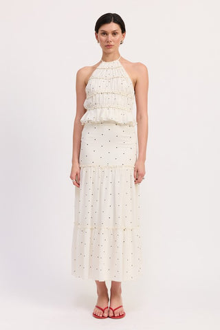 three quarter view cream polka dot A-line tiered midi skirt showing relaxed silhouette and ruffle hem from angle