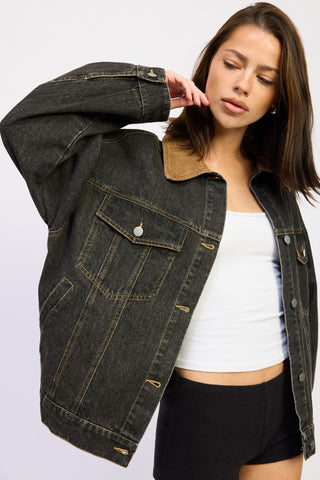 side profile oversized black denim jacket with camel corduroy collar showing drop shoulder silhouette