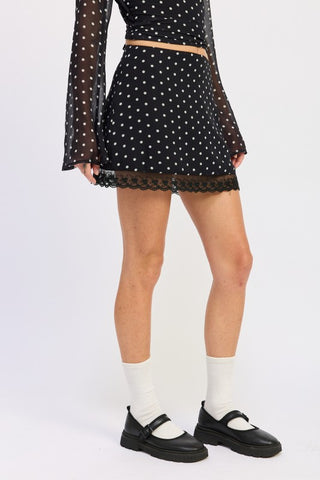 three-quarter view black white polka dot lace hem mini skirt showing fitted cut and scalloped lace edge