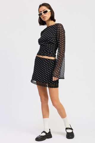 side profile black polka dot mini skirt with lace trim hem showing fitted cut and hem detail