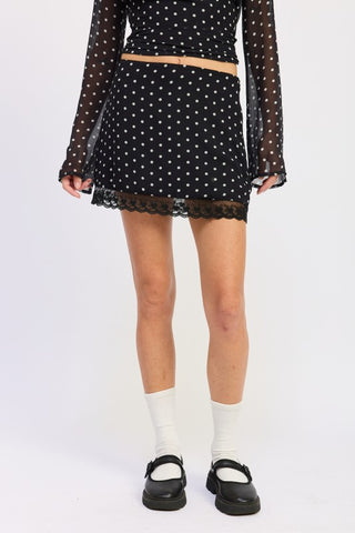 full length model in black polka dot lace hem mini skirt showing fitted hip and above knee length
