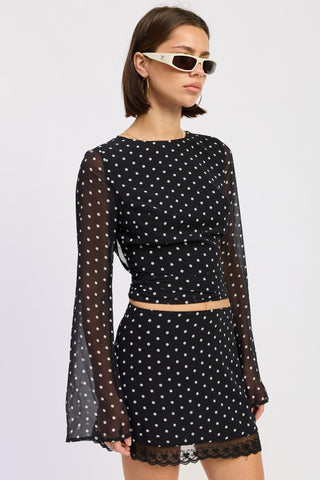 front view black polka dot sheer crop top showing long bell sleeves in motion and lined fitted body