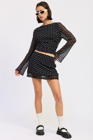 three-quarter view black white polka dot bell sleeve crop top showing open back and sheer mesh sleeve detail
