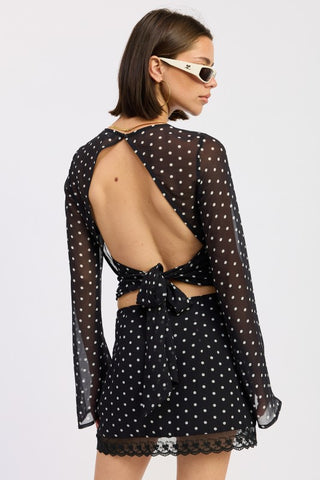 portrait close-up black polka dot bell sleeve sheer top showing stand up neck and polka dot mesh sleeve texture