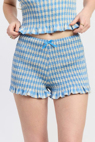 close-up lettuce hem detail Poppy blue gingham smocked shorts showing wavy stretched hem edge construction