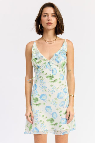 Flora ruffle chiffon mini dress in white with watercolor blue floral print, spaghetti straps, ruffle chest detail and front tie bow