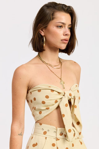 detail shot center front tie bow and large caramel polka dot pattern on butter rayon strapless top