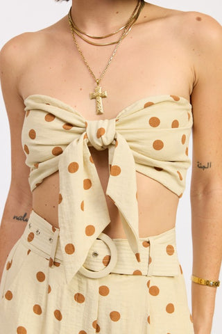 close-up self-tie bow at center chest on butter polka dot strapless tie front crop top