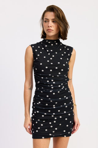 styled pose navy white polka dot mesh mock neck mini dress showing bodycon fit from three-quarter angle