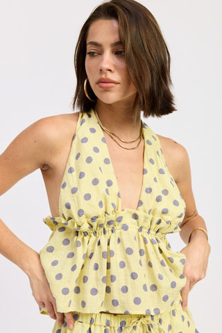 back view yellow polka dot halter top showing open back, tie closure at neck and ruffle hem from behind