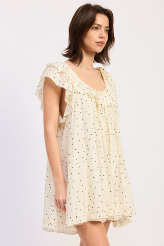 alternate angle showing flutter sleeves and ruffle hem detail on ivory polka dot romper