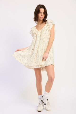 full length model in ivory polka dot babydoll romper with ruffle hem and flutter sleeves visible