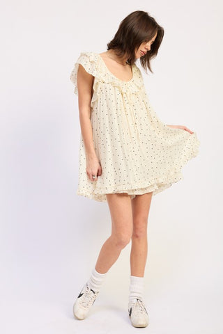 lifestyle shot ivory polka dot babydoll romper in movement showing ruffle flutter