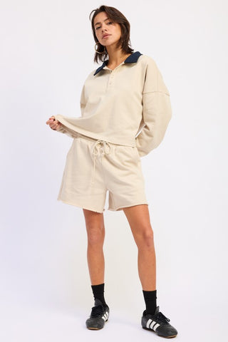 three-quarter view cream navy contrast collar polo crop top showing French terry texture and fit