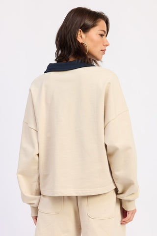 side profile cream pullover polo crop top showing slightly cropped hem and navy polo collar depth