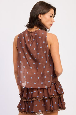 detail shot brown ground with large blue periwinkle polka dot print on twisted halter crop top