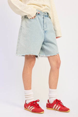 close up hem detail light blue distressed denim bermuda shorts showing frayed raw hem edge and light wash
