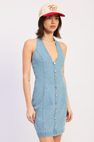 full front view light wash denim halter mini dress with trucker cap showing downtown casual styling and heart snaps