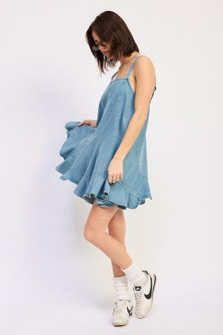 back view light blue denim overall pinafore mini dress showing back strap construction and diagonal panels
