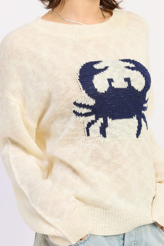 close up cream ivory slub knit sweater showing large navy blue crab intarsia motif on chest and slub texture detail