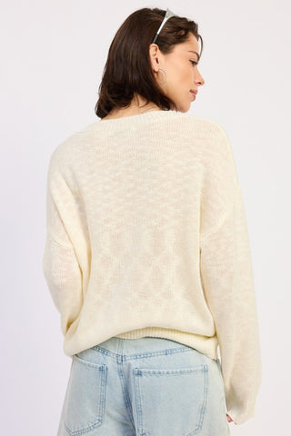 editorial styling cream crab intarsia graphic knit sweater with denim bermuda shorts white socks and sneakers
