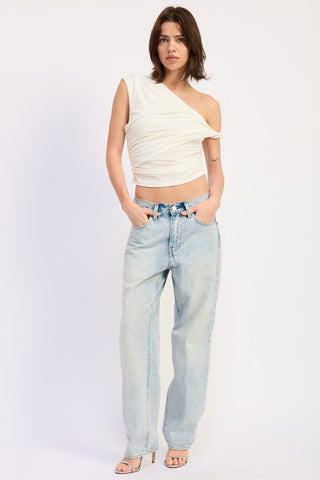 three quarter front view cream one shoulder crop top showing diagonal twist and ruching detail from angle