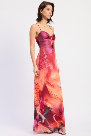 model wearing floral halter maxi dress outdoor setting, full length botanical print in warm pinks oranges coral teal