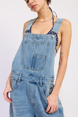 close up bib front denim barrel overall showing chest patch pocket metal buckle straps and star embroidery detail