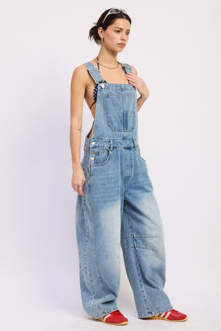 lower half detail medium wash denim barrel overall showing distressed knee whisker fading and floor-grazing leg width