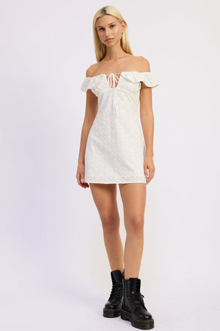 Woman wearing a white off-shoulder dress against a light purple background