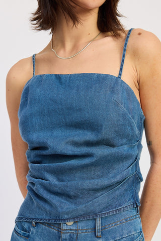 Blue denim top worn by a person on a white background