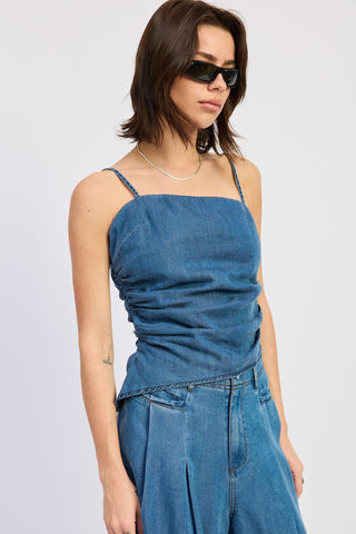 Woman wearing a blue denim dress against a plain background