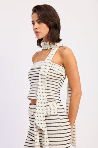 Woman wearing a black and white striped dress with a high collar on a white background