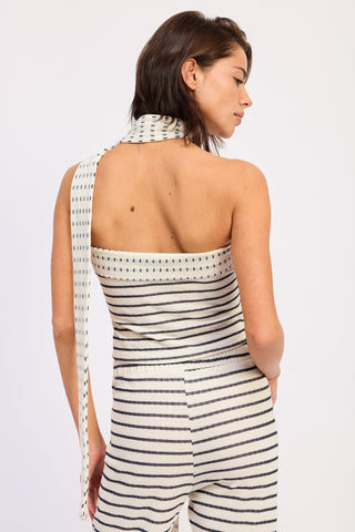 Woman wearing a black and white striped dress with a plain background