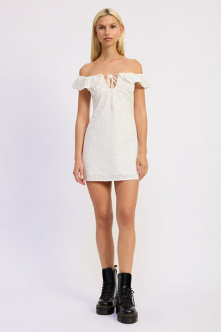 Woman wearing a white off-shoulder dress with black boots on a white background