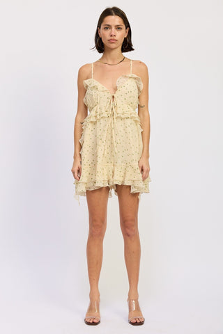 Woman wearing a yellow ruffle romper on a white background