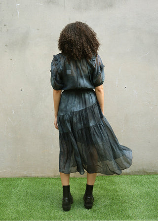 Back view of navy sheer dress showing keyhole closure and tiered design